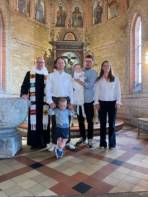 Dåbsbarn med familie og præsten