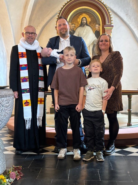 Dåbsbarn med familie og præsten