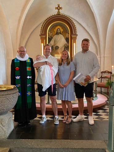 Billede af præsten og dåbsforældre, dåbsbarn og endnu en mand. 