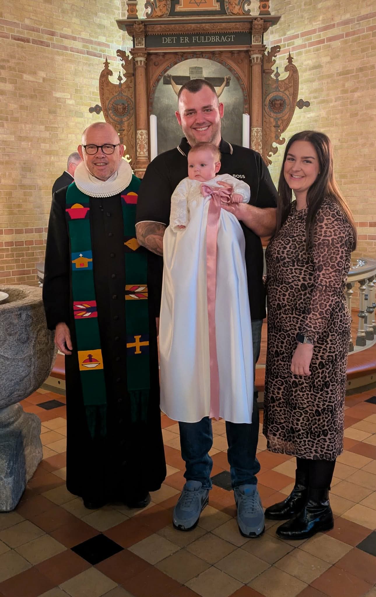 Dåbsbarn med familie og præsten