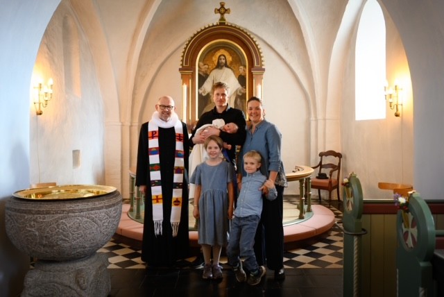 Dåbsbarn med familie og præsten