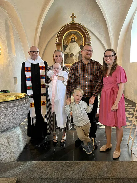 Dåbsbarn med familie og præsten